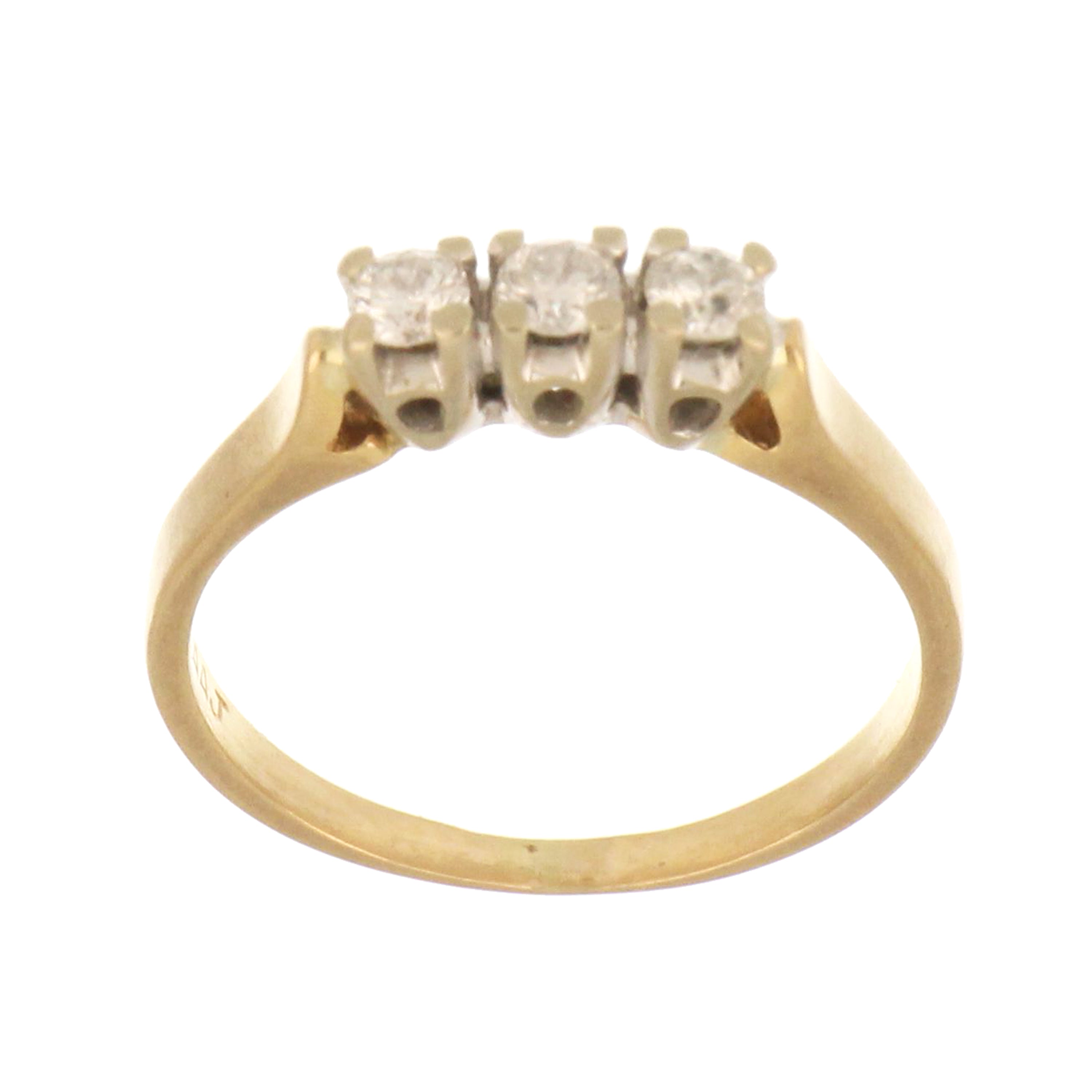 14kt yellow gold three-stone diamond ring with round brilliant diamonds.