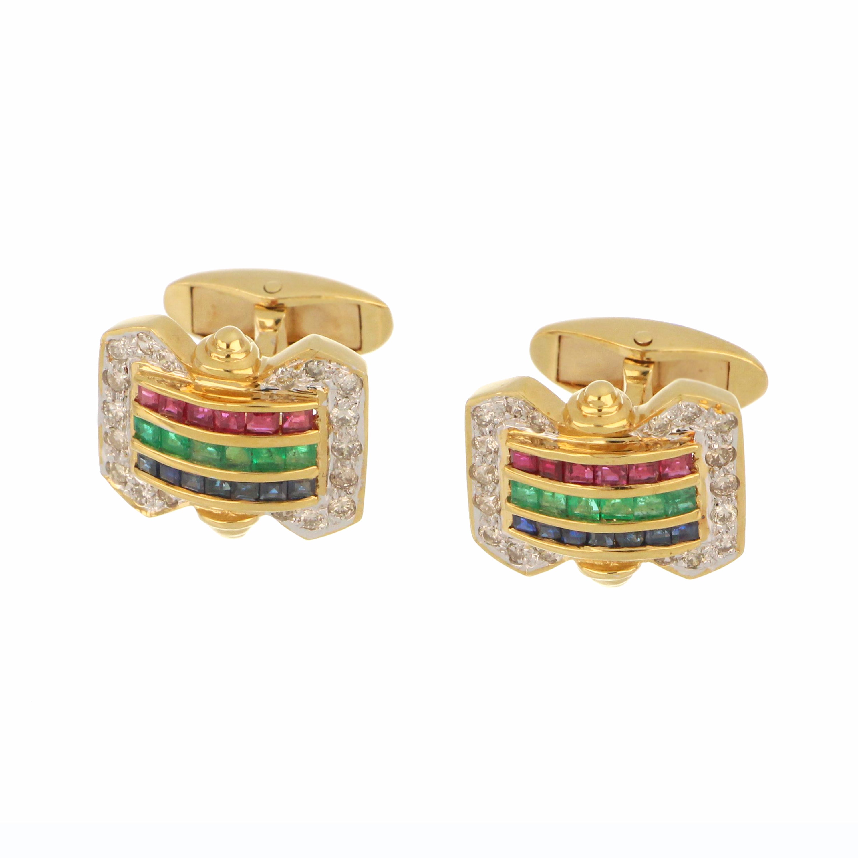Close-up view of 18kt yellow gold cufflink featuring step-cut blue sapphires, rubies, emeralds and full-cut diamonds, showcasing gemstones and polished gold