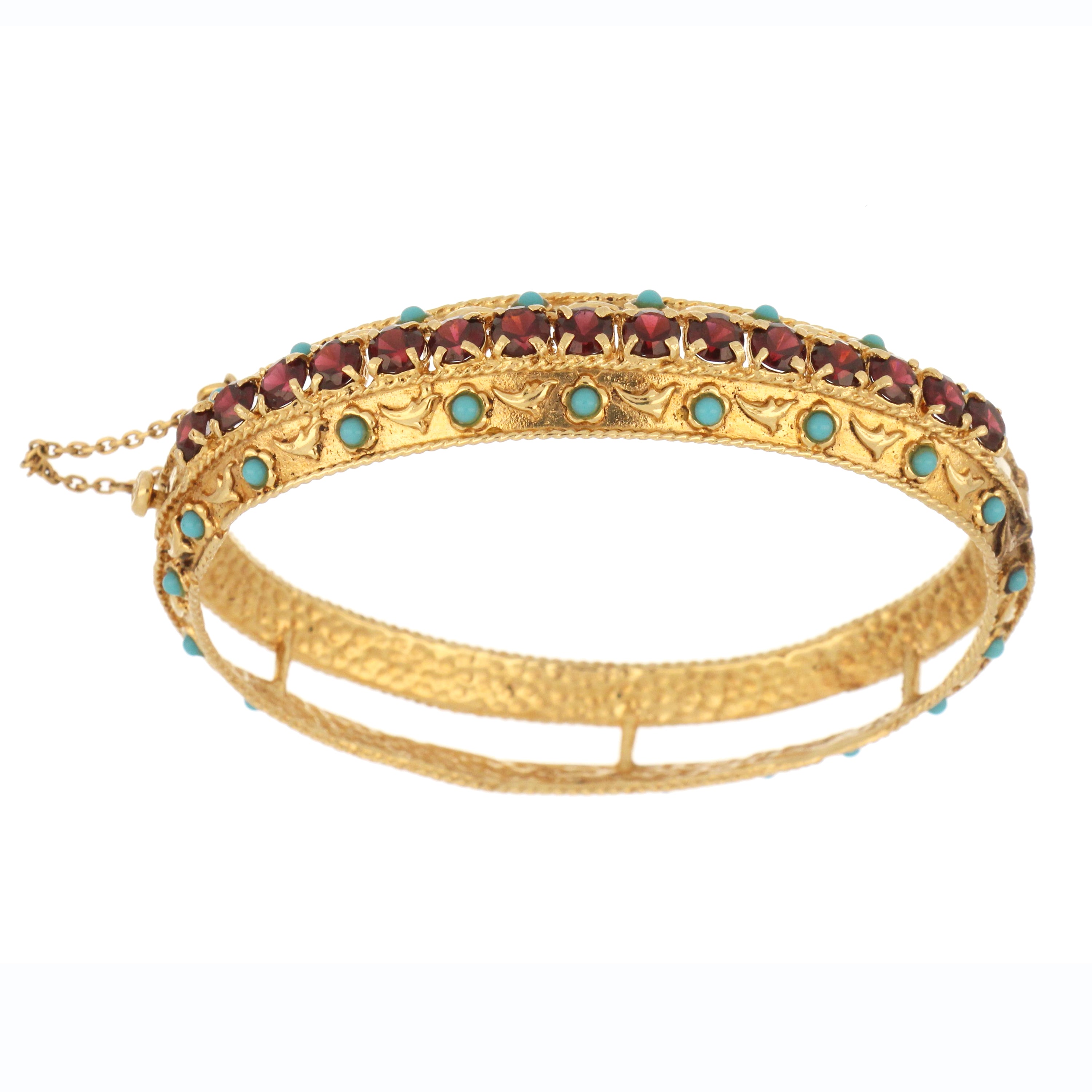 Close-up of 10kt yellow gold bangle featuring round garnet stones and turquoise beads, showcasing polished gold surface