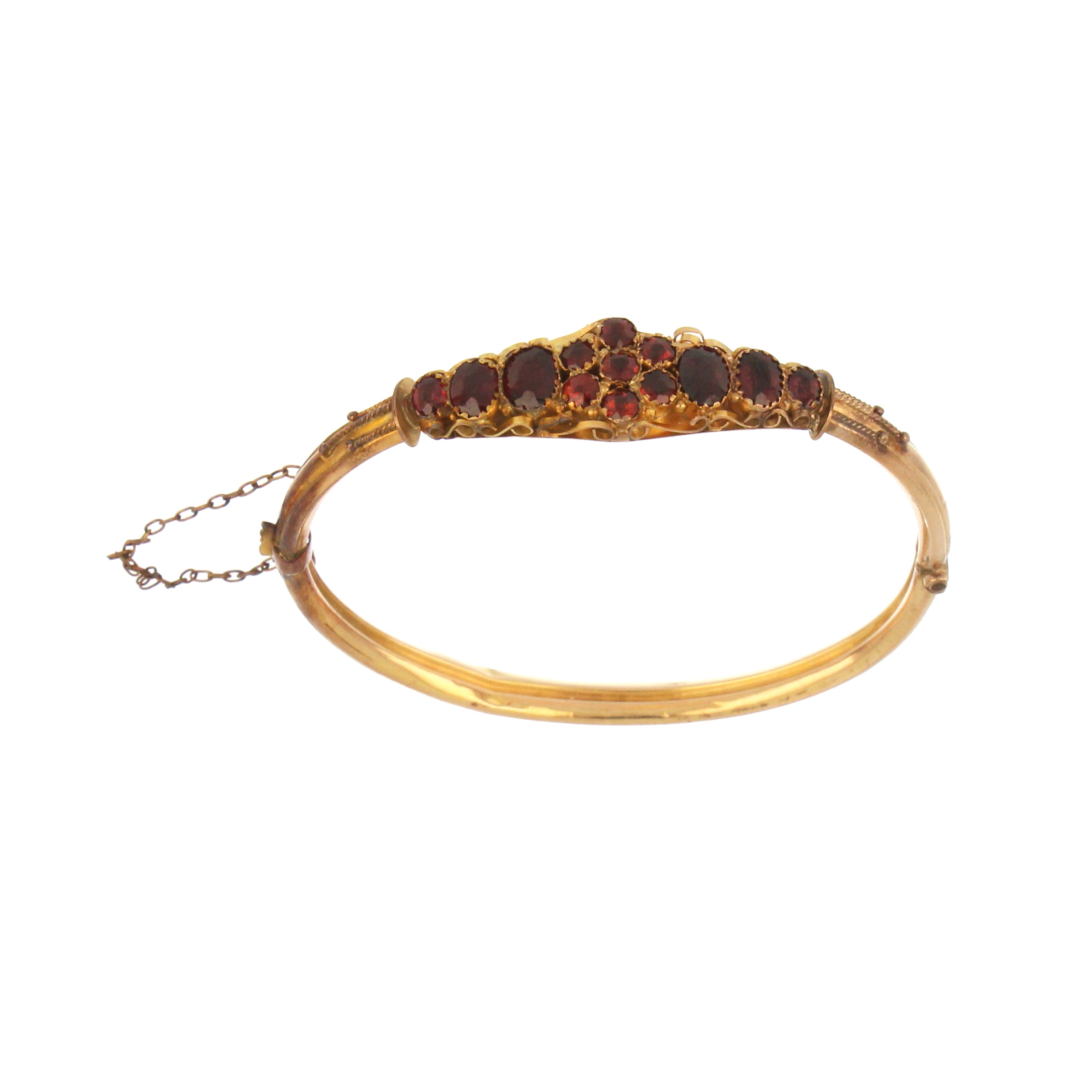 Close-up angled view of 9kt yellow gold bangle featuring 6 oval and 7 round natural garnet stones, total weight 8.56 grams