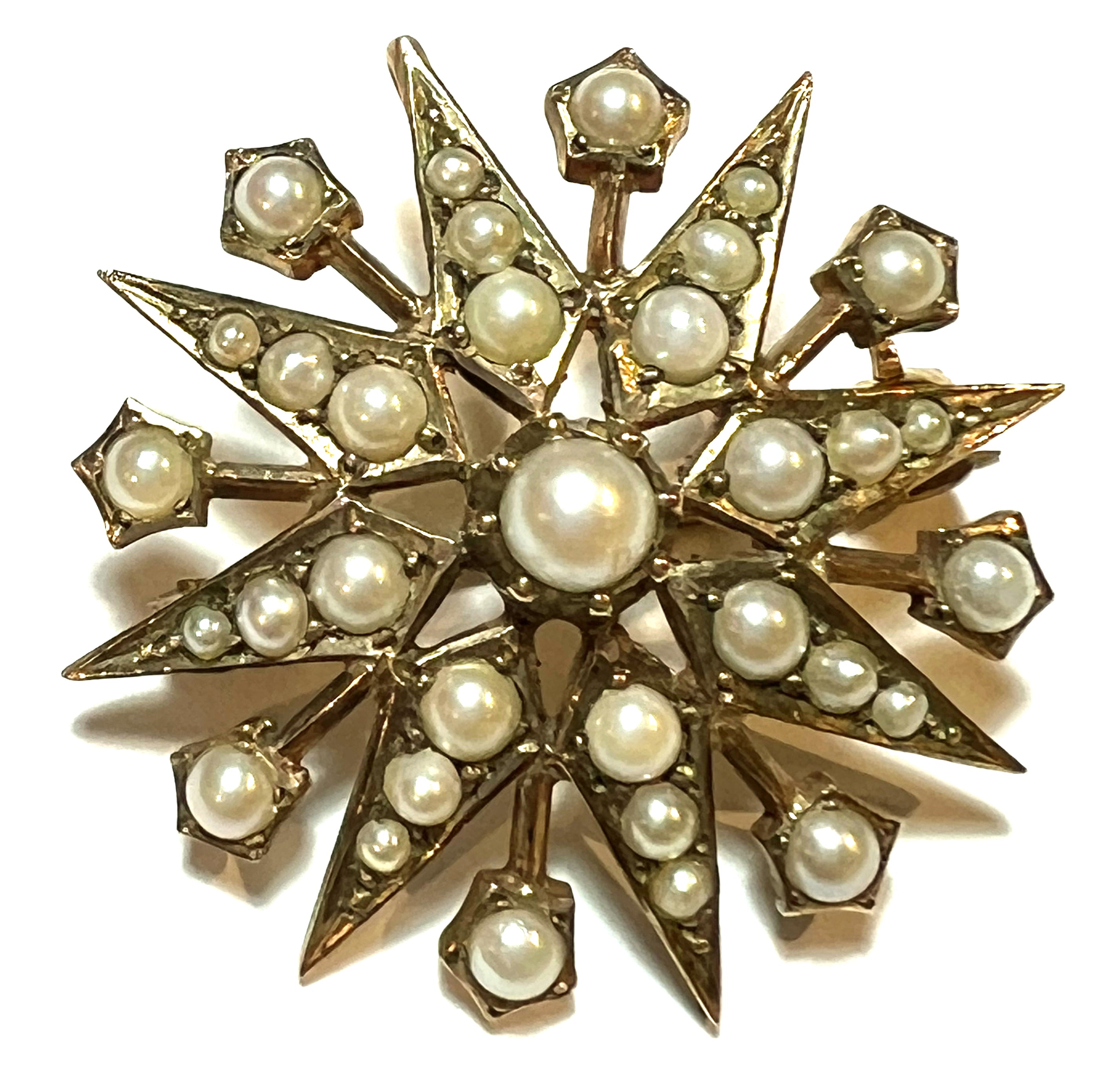 Close-up of elegant 9kt yellow gold pearl brooch with seed pearls from top angle