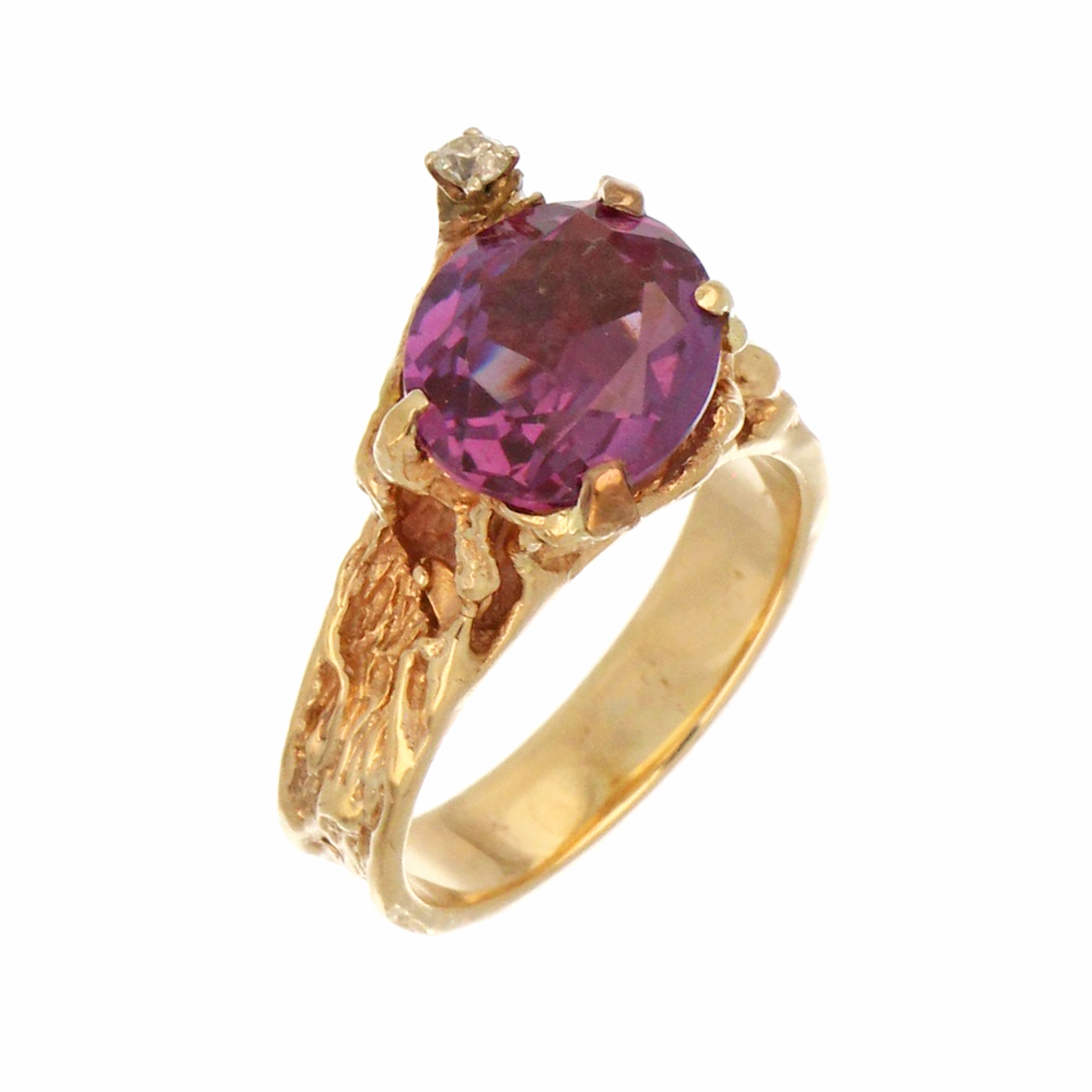 Close-up of oval synthetic alexandrite 12x10mm set in 10kt yellow gold ring, showing stone and band detail