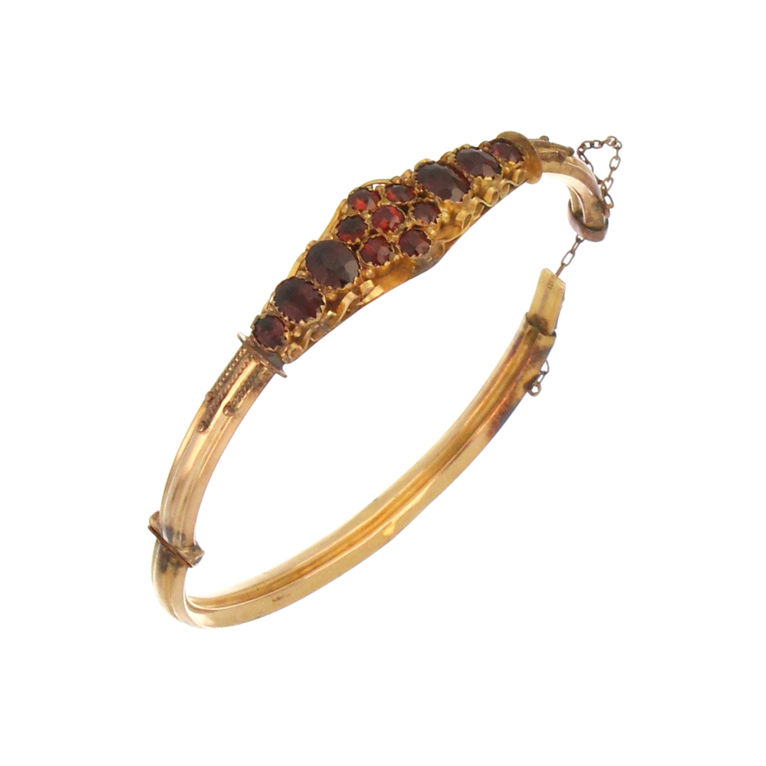 Top-down image showing the layout of oval and round garnets on a 9kt yellow gold collectible bangle