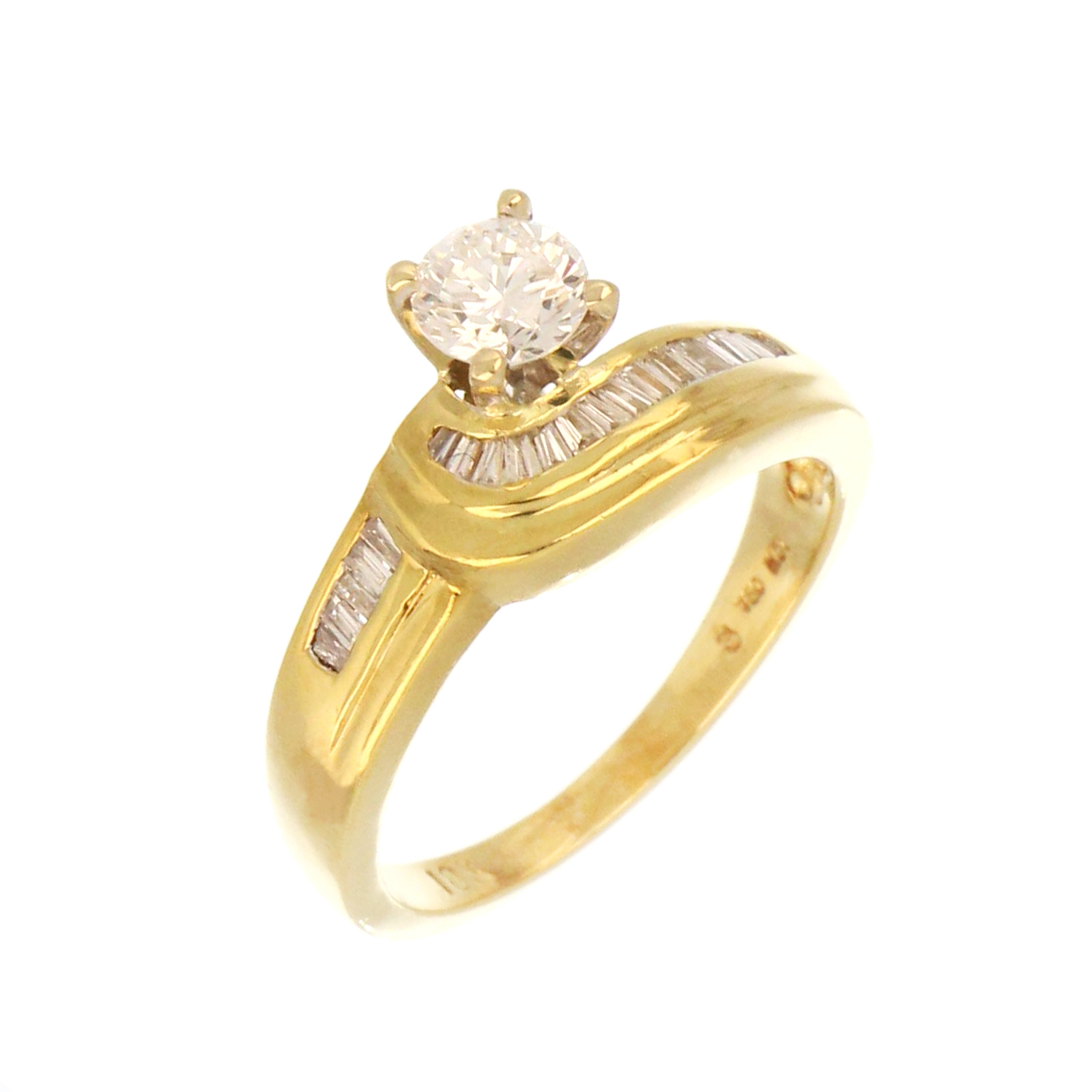 18kt yellow gold diamond engagement ring showcasing round brilliant and tapered baguette diamonds, close-up front angle