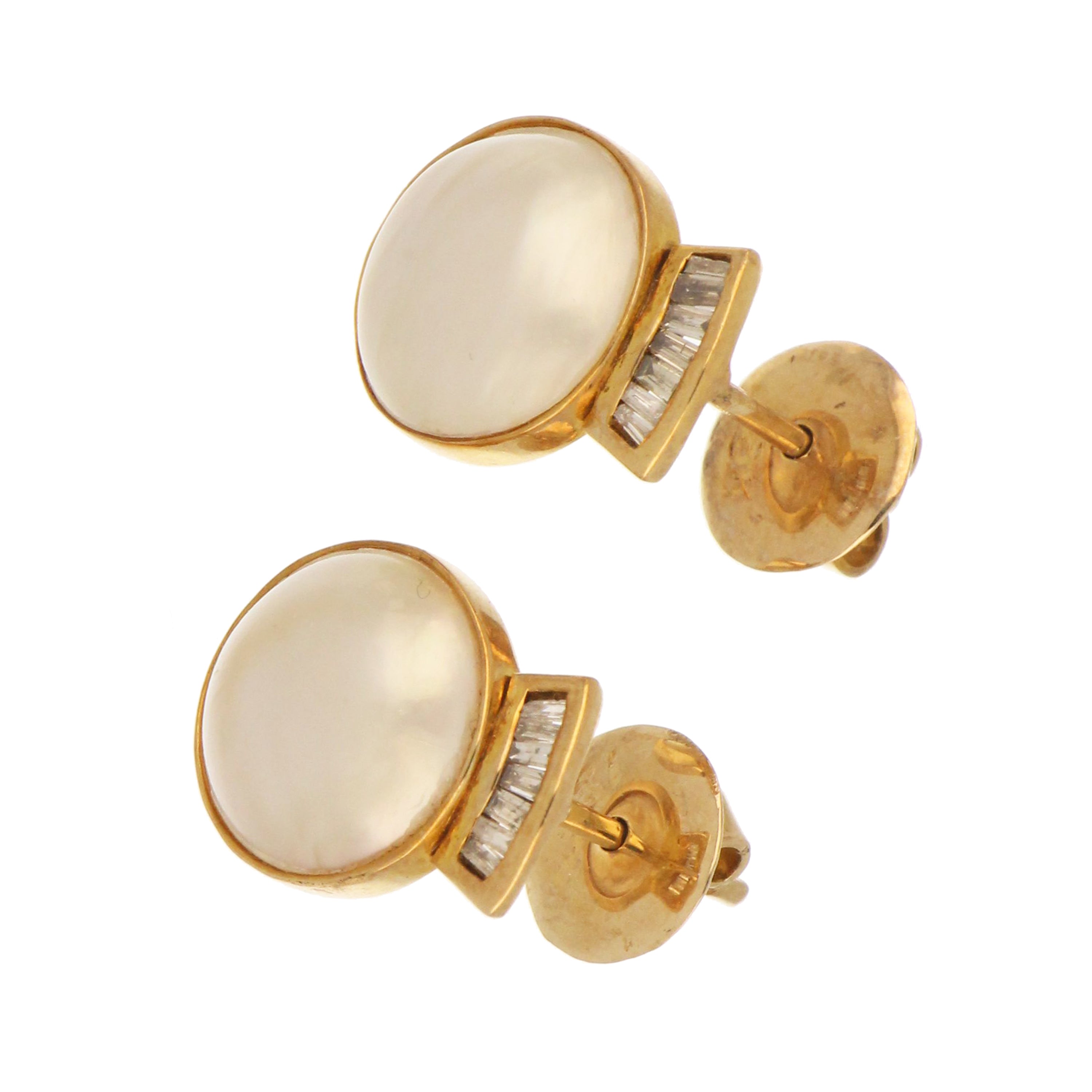 side angle of 18kt yellow gold mabe pearl earrings showing channel-set baguette diamonds
