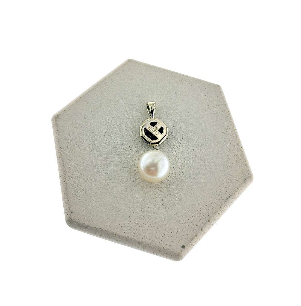 Side angle of 14kt white gold pendant featuring cultured pearl, blue sapphires, and single cut diamonds totaling 2.61 grams