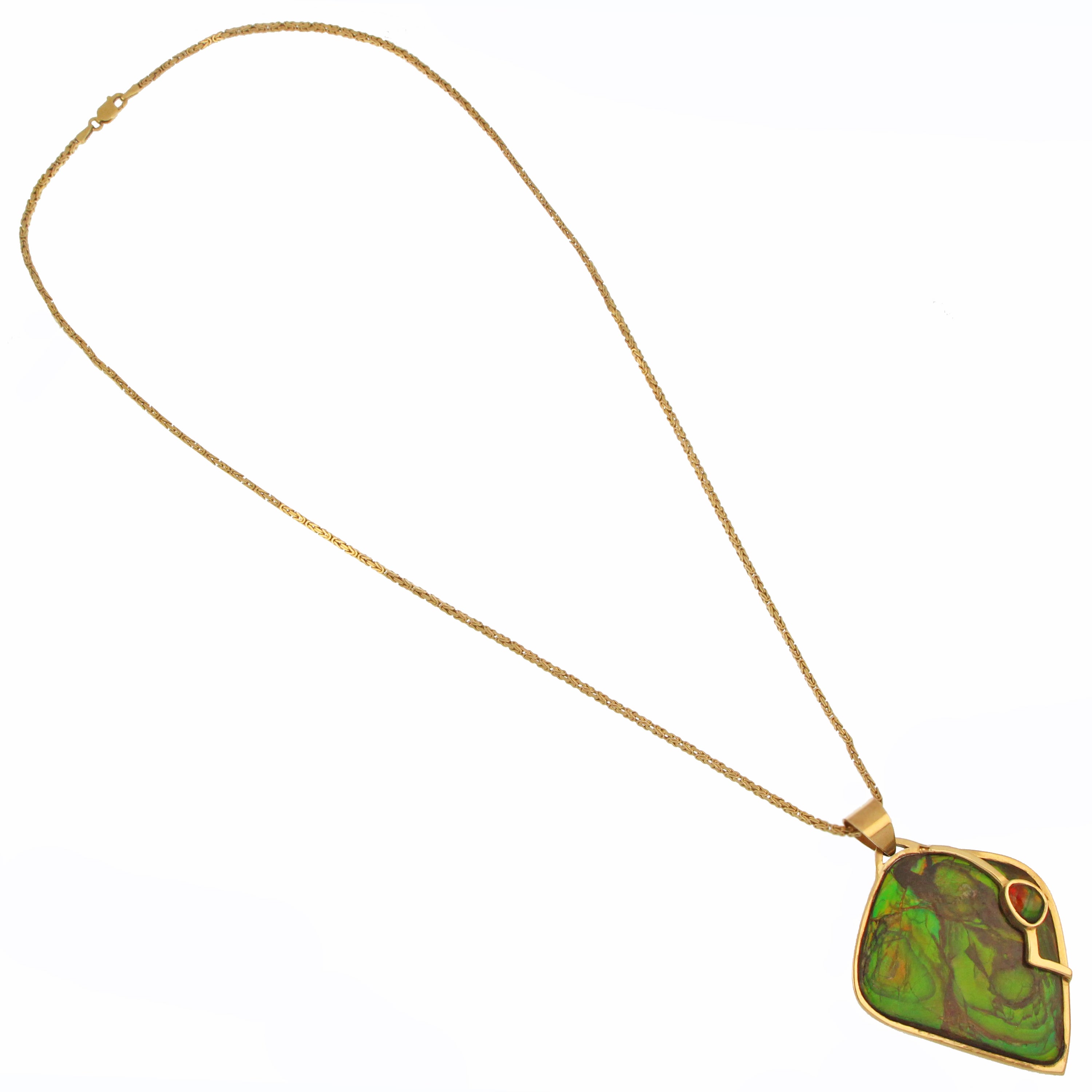 Artistic angle shot showcasing 14kt yellow gold pendant with vibrant red and green ammolite stones