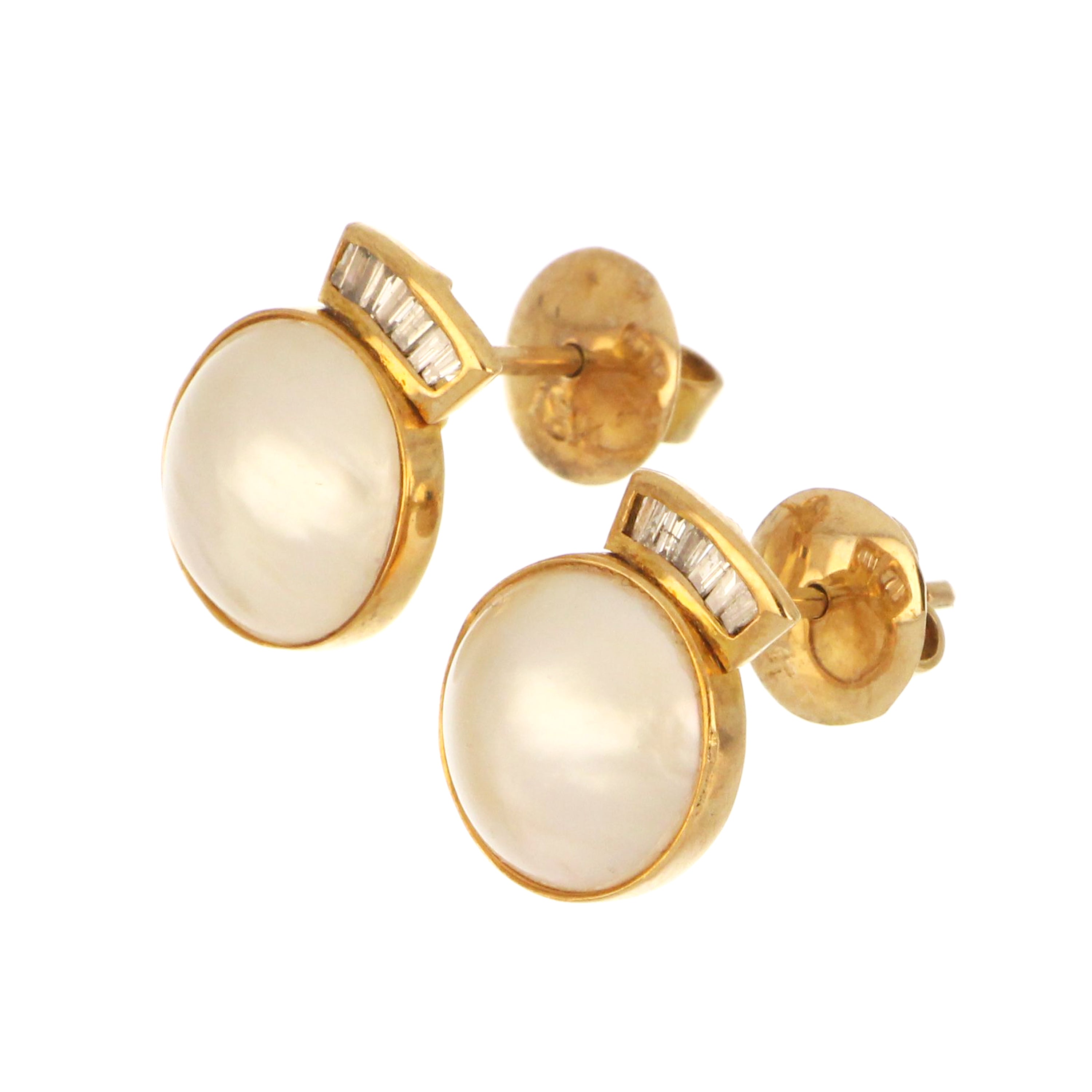 close-up of 18kt yellow gold mabe pearl earrings featuring white pearls and SI2-SI3 clarity baguette diamonds