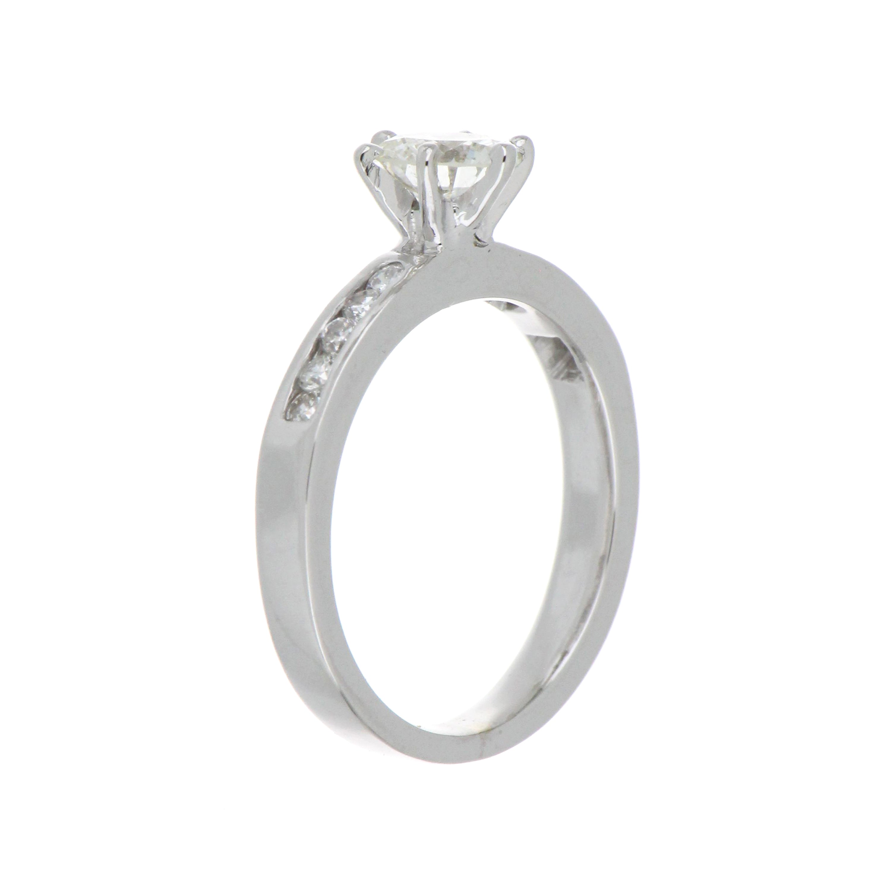 Top-down view showing the round brilliant center diamond with SI1 clarity and J color on a 19kt white gold ring