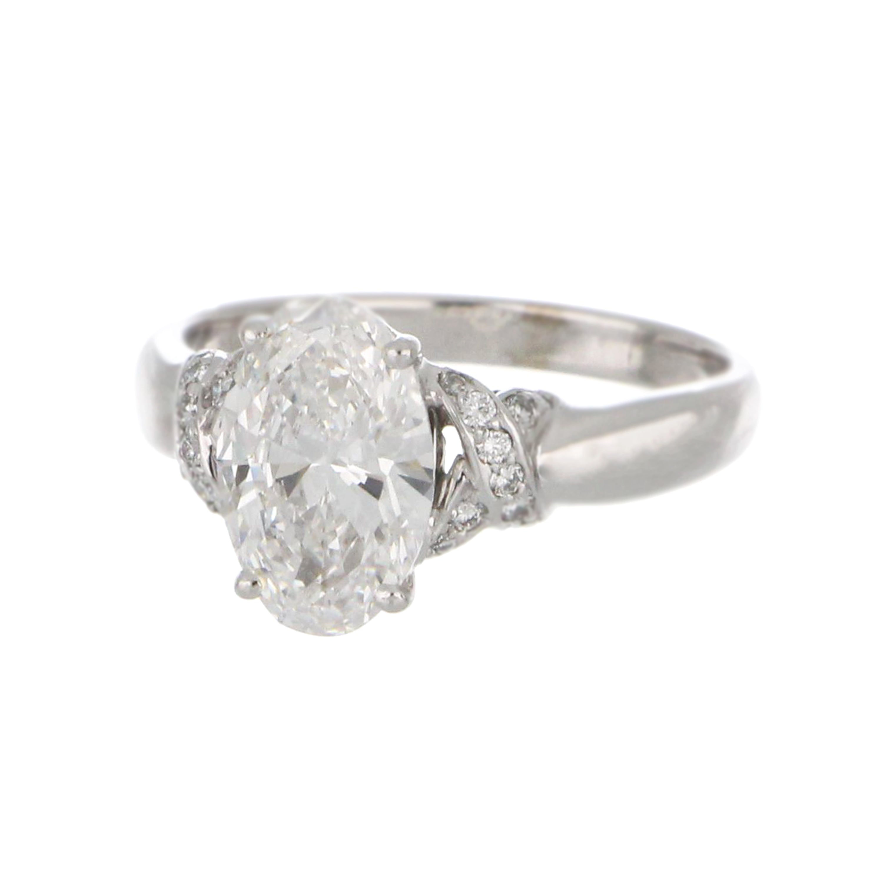 Side profile of 18kt white gold ring with oval 2.38ct diamond and 18 round full cut diamonds on shoulders