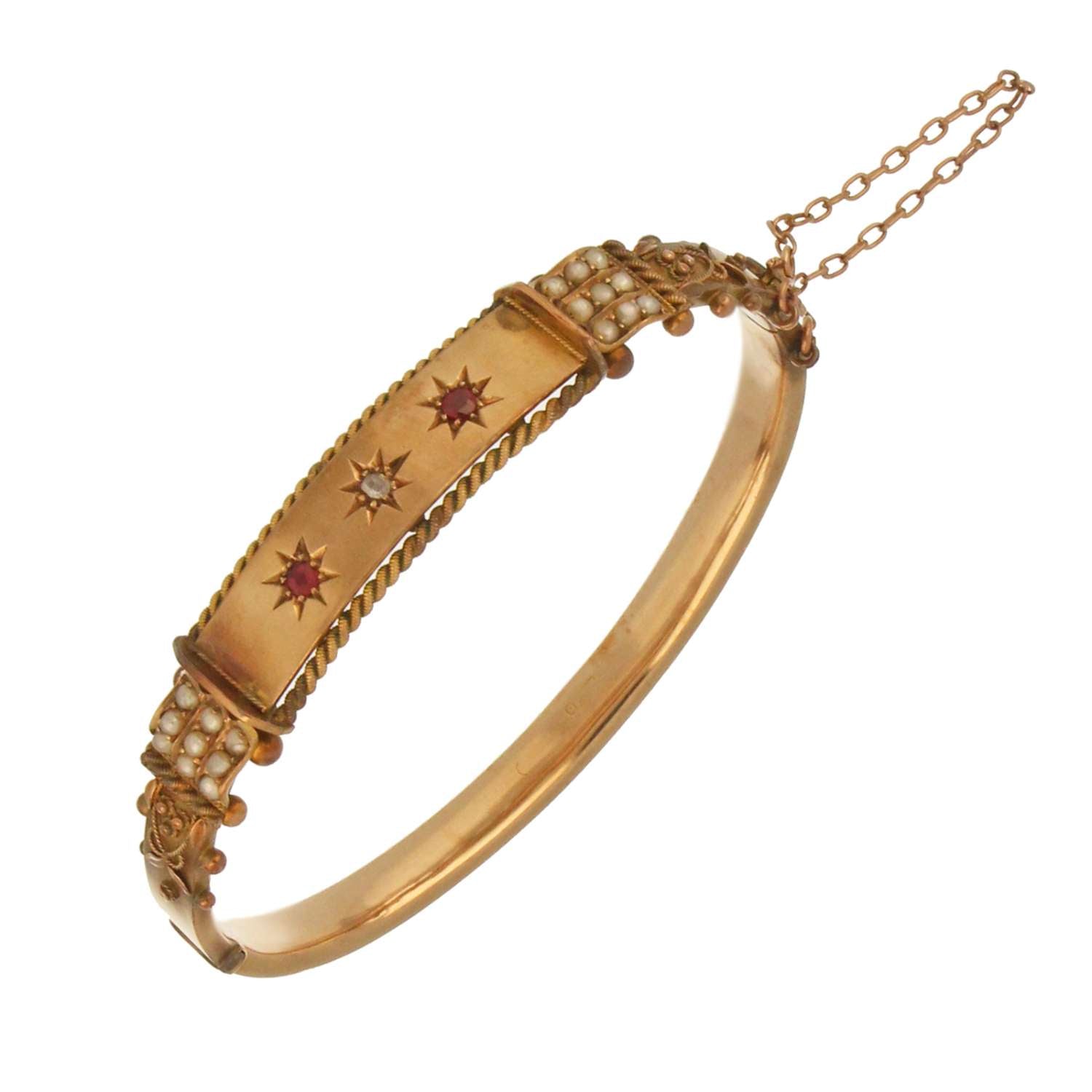 Vintage gold bangle with gemstone accents including rubies, diamond, and pearls