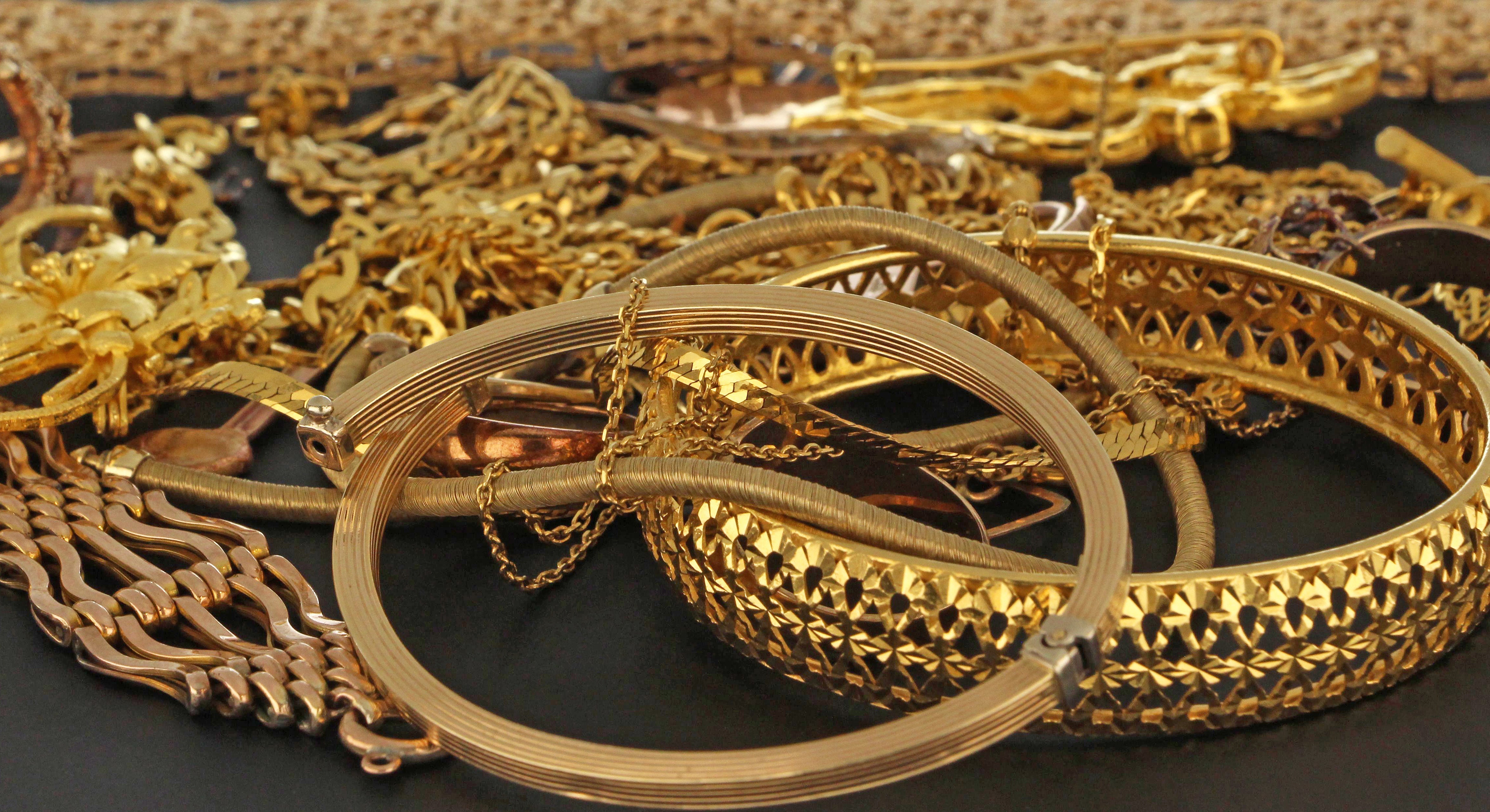 Close-up of 24 karat gold jewellery sample weighing 1 gram, showcasing rich yellow pure gold metal surface