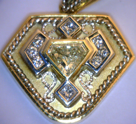 Front view of ladies' diamond pendant in yellow and white gold showcasing central round brilliant diamond and sparkling accent diamonds