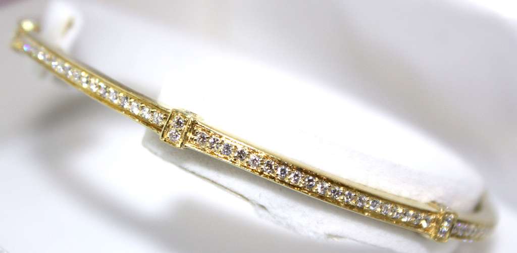Angled view of fine 18kt yellow gold diamond bangle displaying detailed craftsmanship and brilliant VS clarity diamonds totaling 1.37cttw
