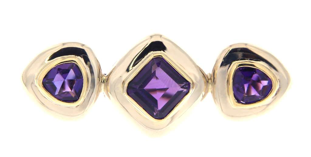 14kt white and yellow gold brooch with three step-cut purple amethysts, front angle showcasing bezel settings