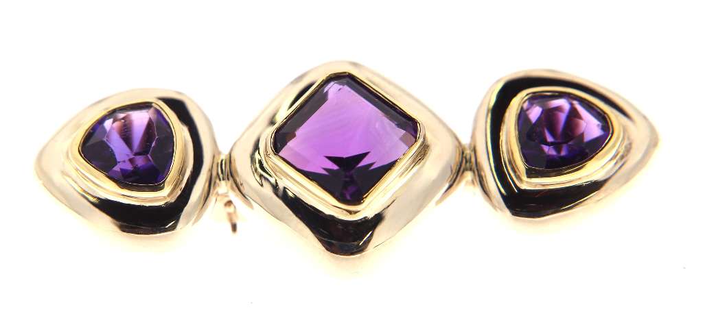 Close-up of 14kt two-tone gold amethyst brooch highlighting the step-cut stones and polished finish