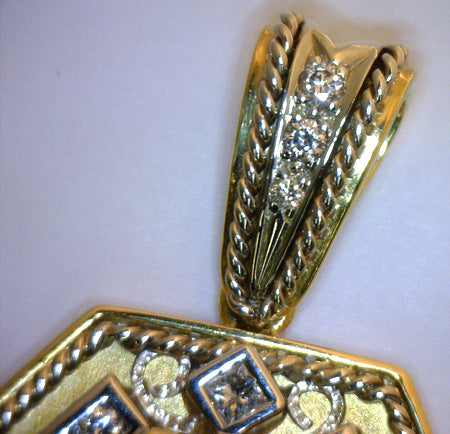 Detailed shot of pendant bail adorned with round brilliant cut diamonds in 18kt gold