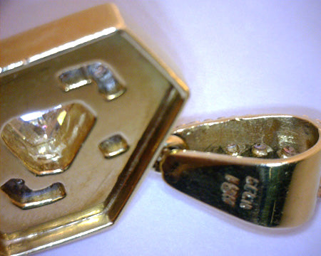 Elegant 18kt yellow and white gold pendant photographed against black background emphasizing diamond brilliance