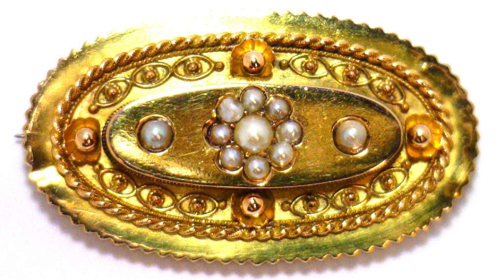 Close-up of 15kt yellow gold brooch featuring 11 white seed pearls arranged delicately on antique fine jewelry piece, showing top surface details