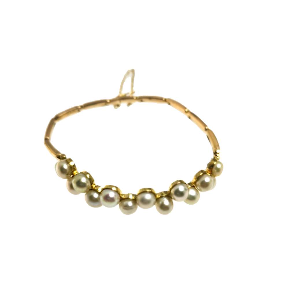 Close-up of 15kt yellow gold bracelet with smooth round freshwater pearls and safety chain detail
