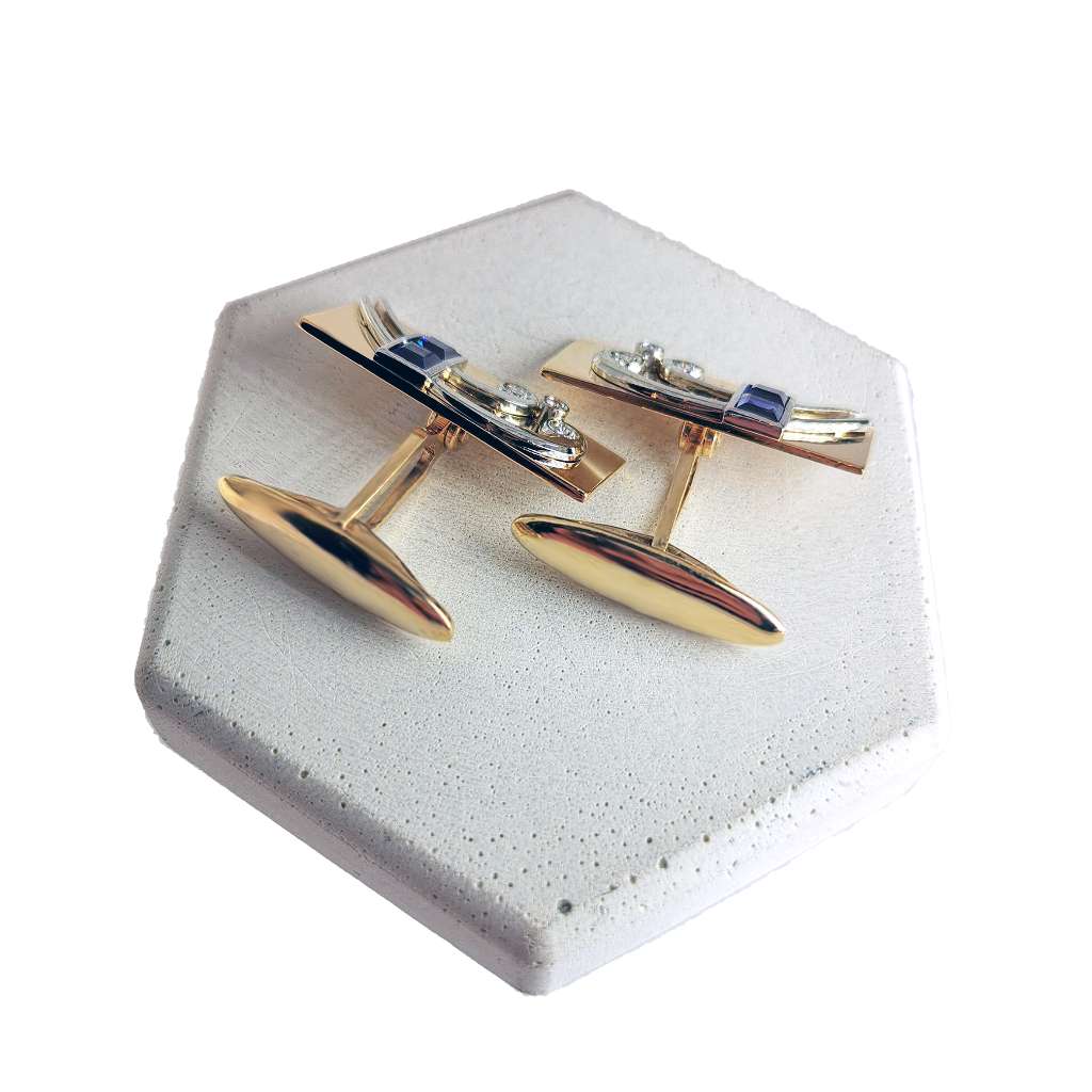 Side angle of rectangular 14kt yellow gold cufflinks highlighting the blue sapphires and diamond accents with polished finish