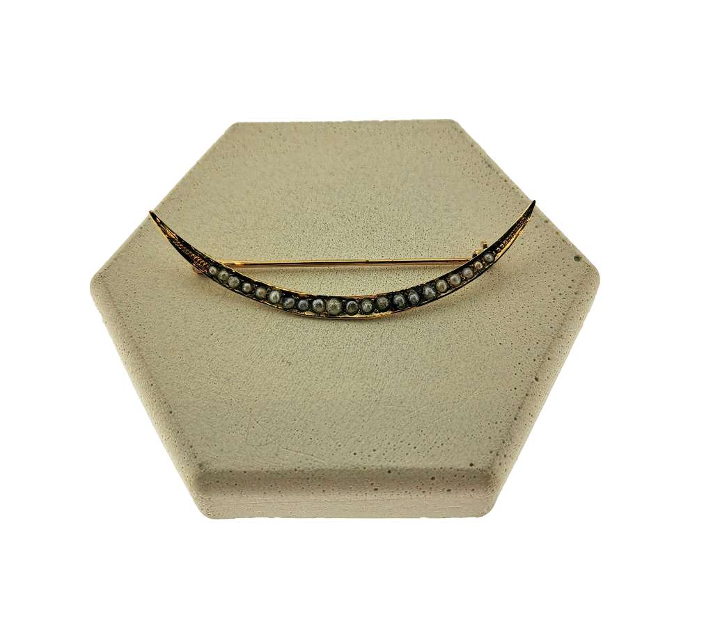 14kt yellow gold moon style brooch adorned with 21 white seed pearls, close-up angle showcasing delicate pearl settings and crescent motif