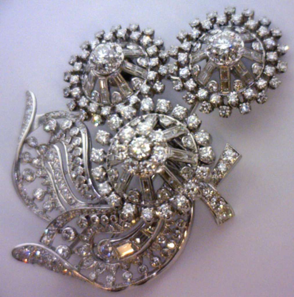 Close-up angle of Victorian flower style brooch highlighting claw settings of round and baguette cut diamonds