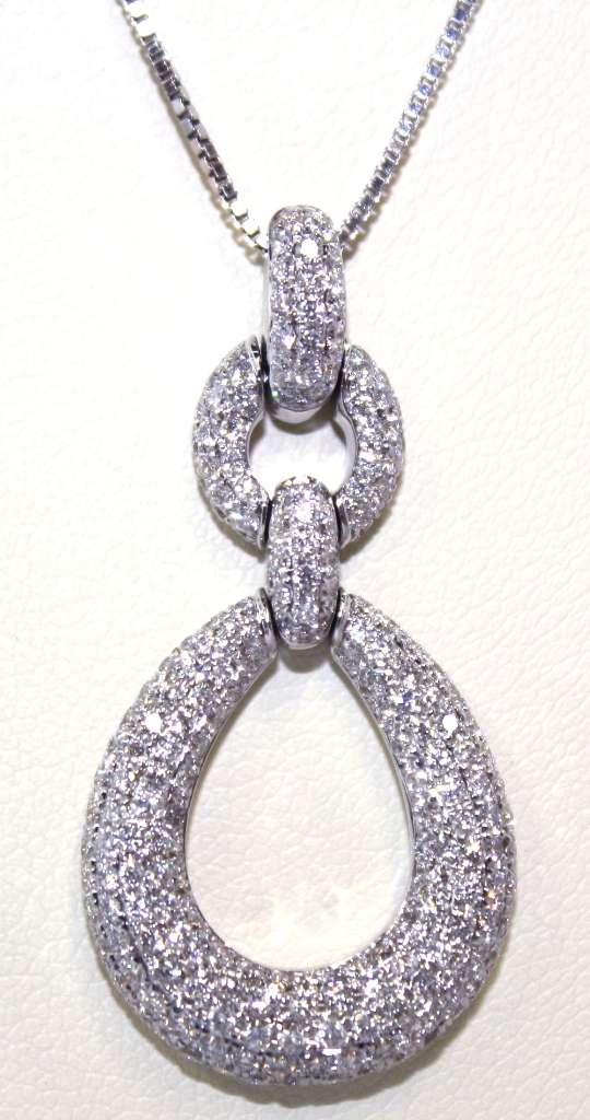 Close-up detail of 18kt white gold pendant's multiple sparkling diamonds with G-H color