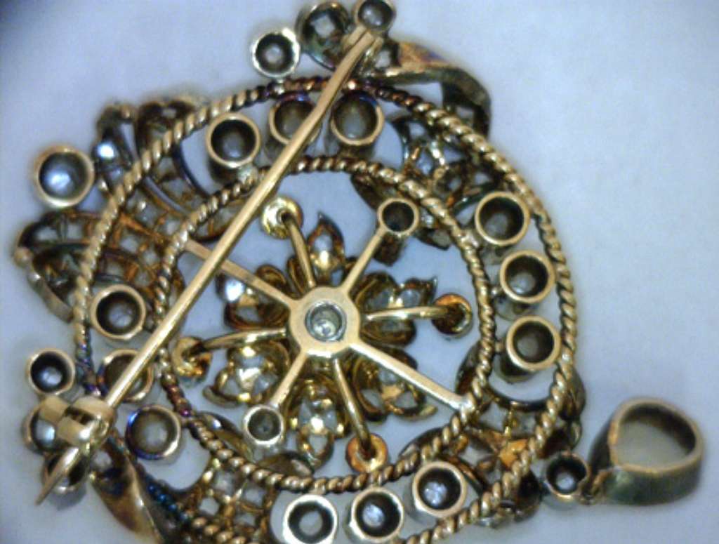 Elegant Victorian collectible brooch close-up showing intricate metalwork and white opal centerpiece