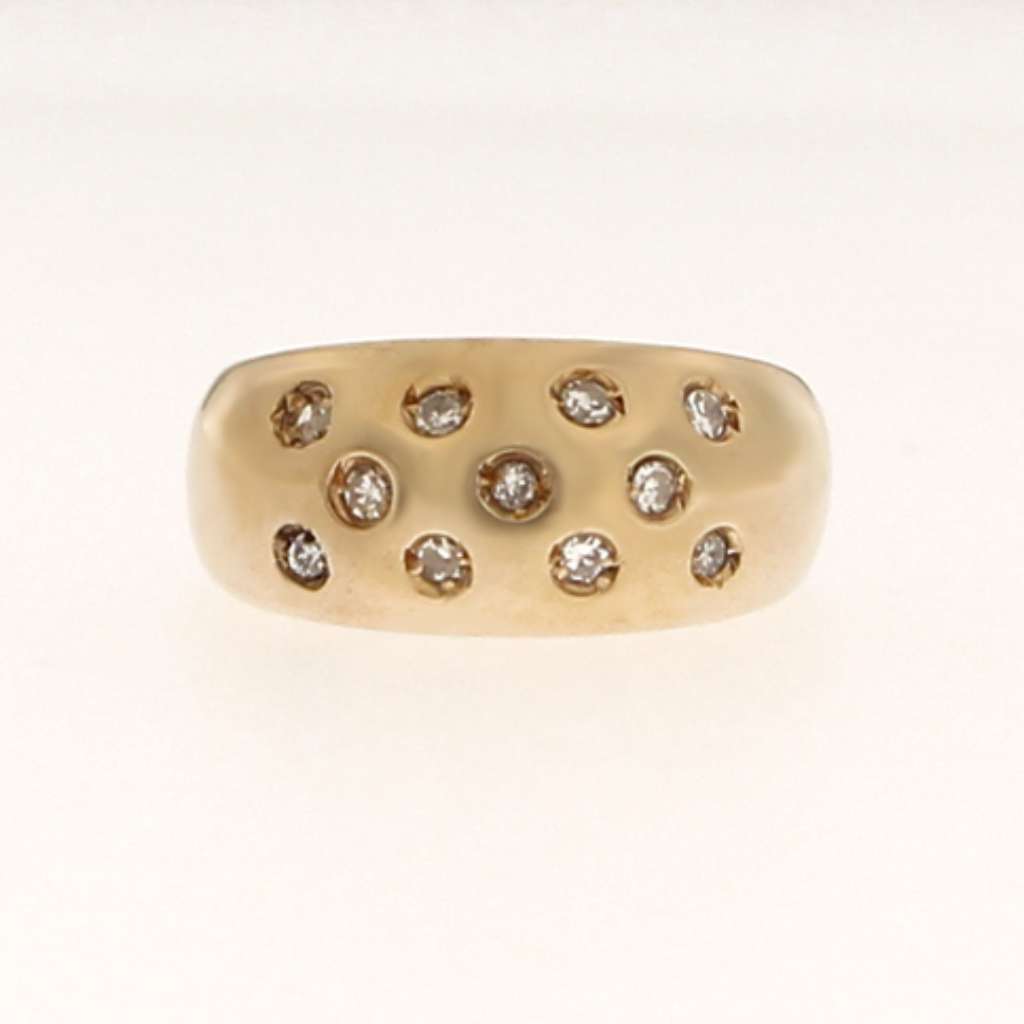 Close-up angle of 10K yellow gold diamond dome ring showing diamond clarity and gypsy setting detail