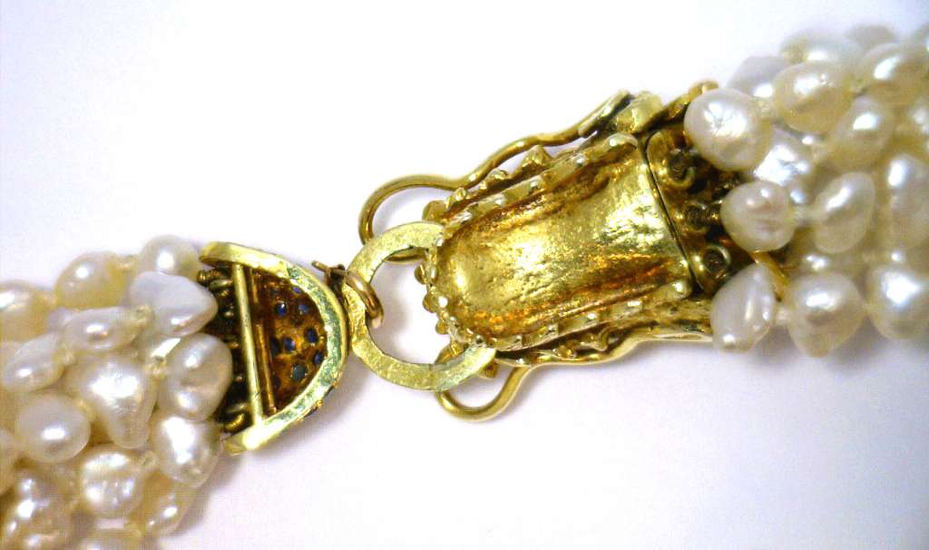Full length view of eight strand freshwater pearl bracelet with intricate yellow gold clasp set with sapphires and diamonds
