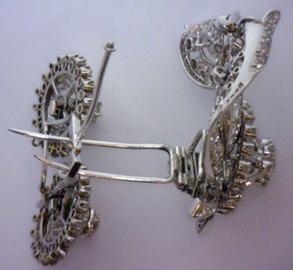Antique diamond brooch on white background showing weight and metal sheen