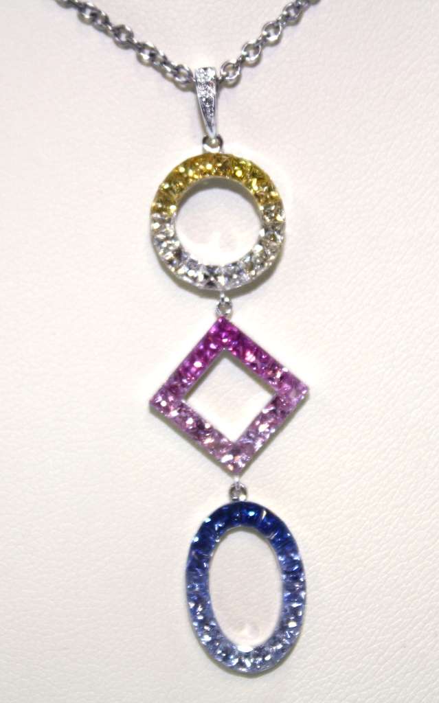 18kt white gold pendant featuring 54 round sapphires in yellow, white, pink, and blue hues, front view showcasing intricate gemstone arrangement