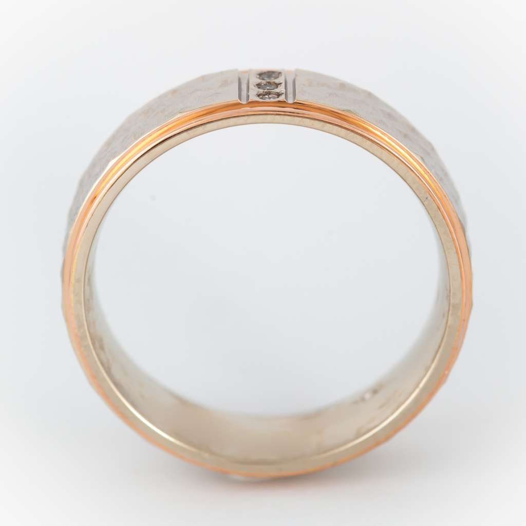 Top view of refined 10kt rose and white gold band with three round diamonds totaling 0.03 cttw, showcasing the sparkle and craftsmanship