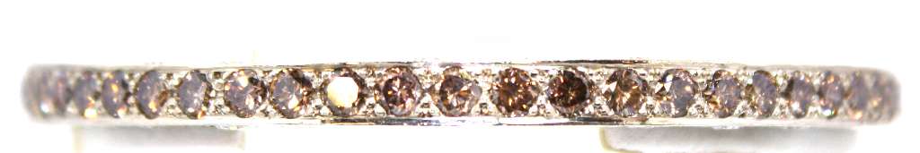 Close-up angle of 18kt white gold bangle featuring brownish yellow and white round brilliant cut diamonds