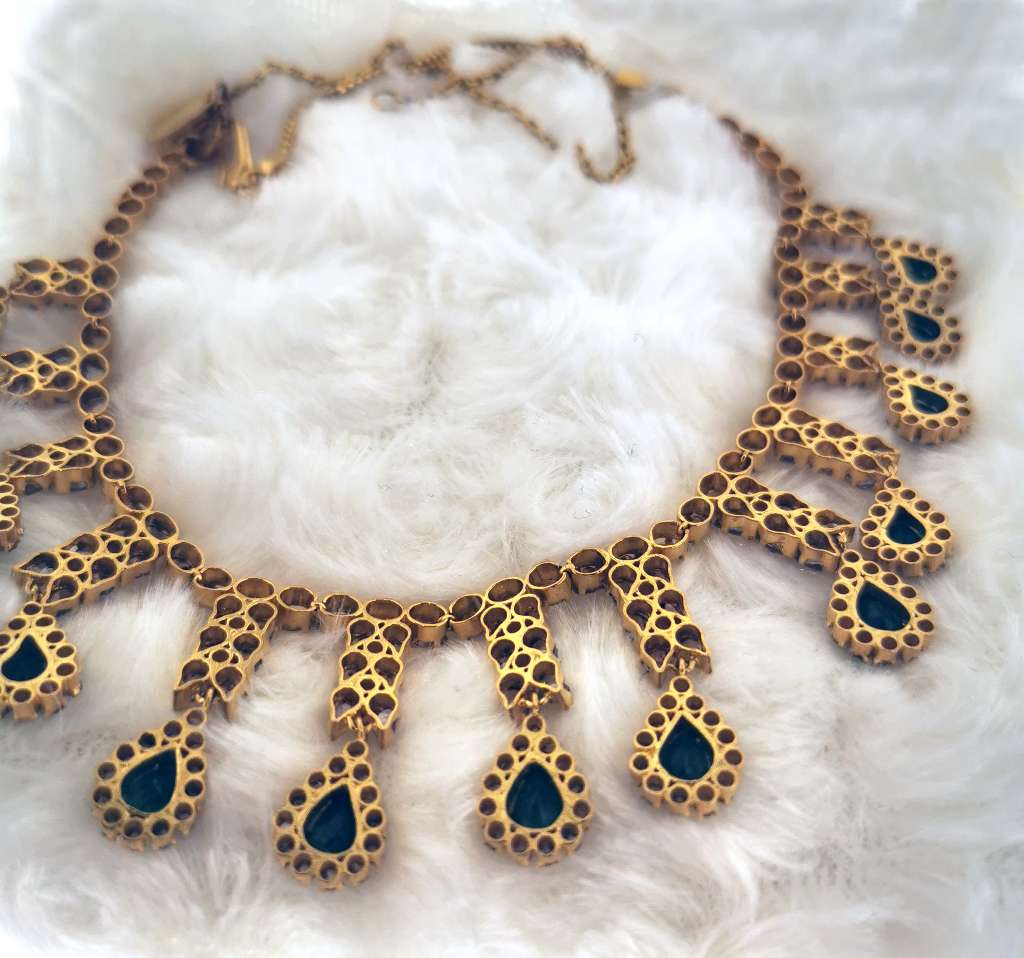 Detailed craftsmanship of 291 rose cut diamonds and 13 pear shaped emeralds on 22kt gold necklace