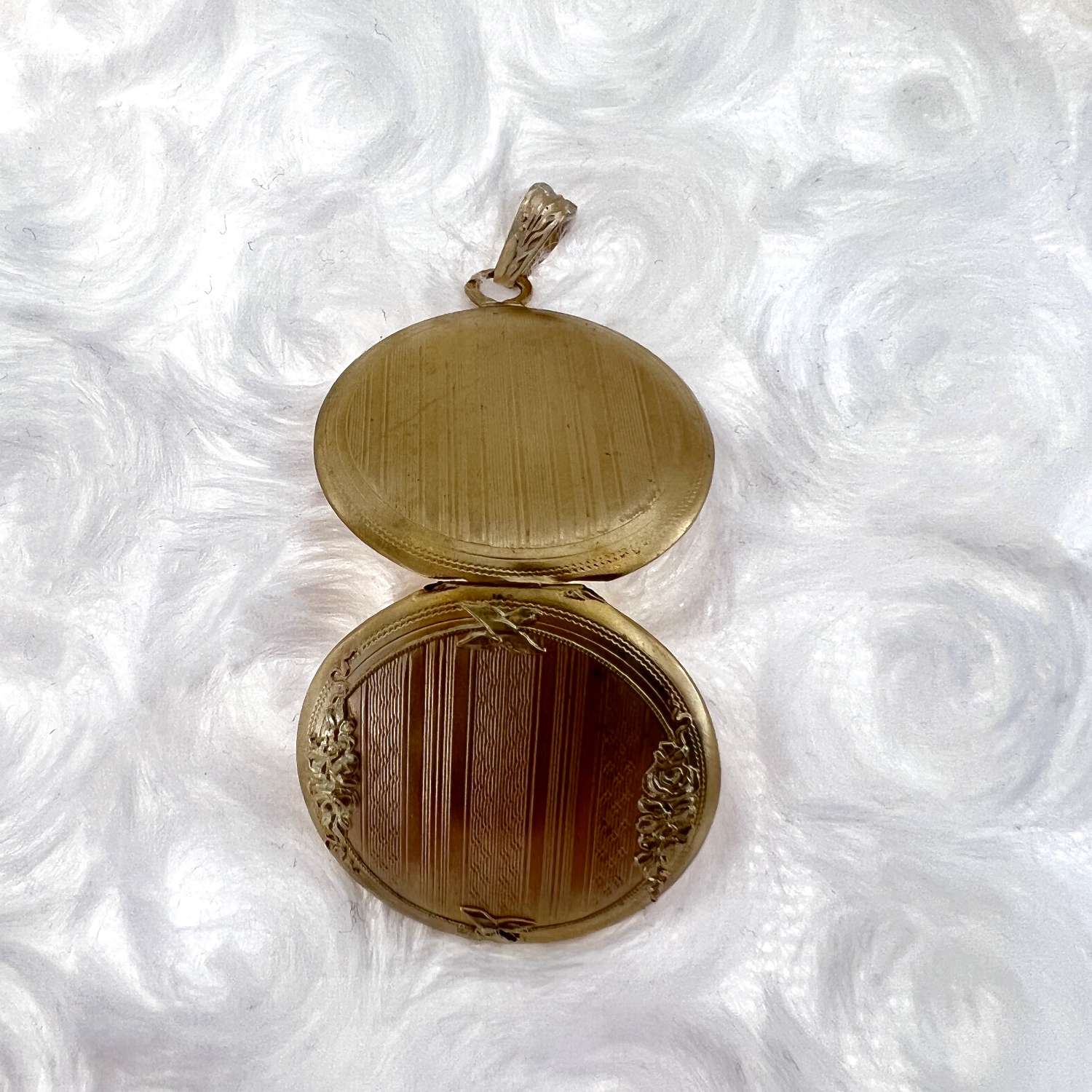 Close-up of 18kt yellow gold locket pendant front, highlighting classic round shape and fine finish