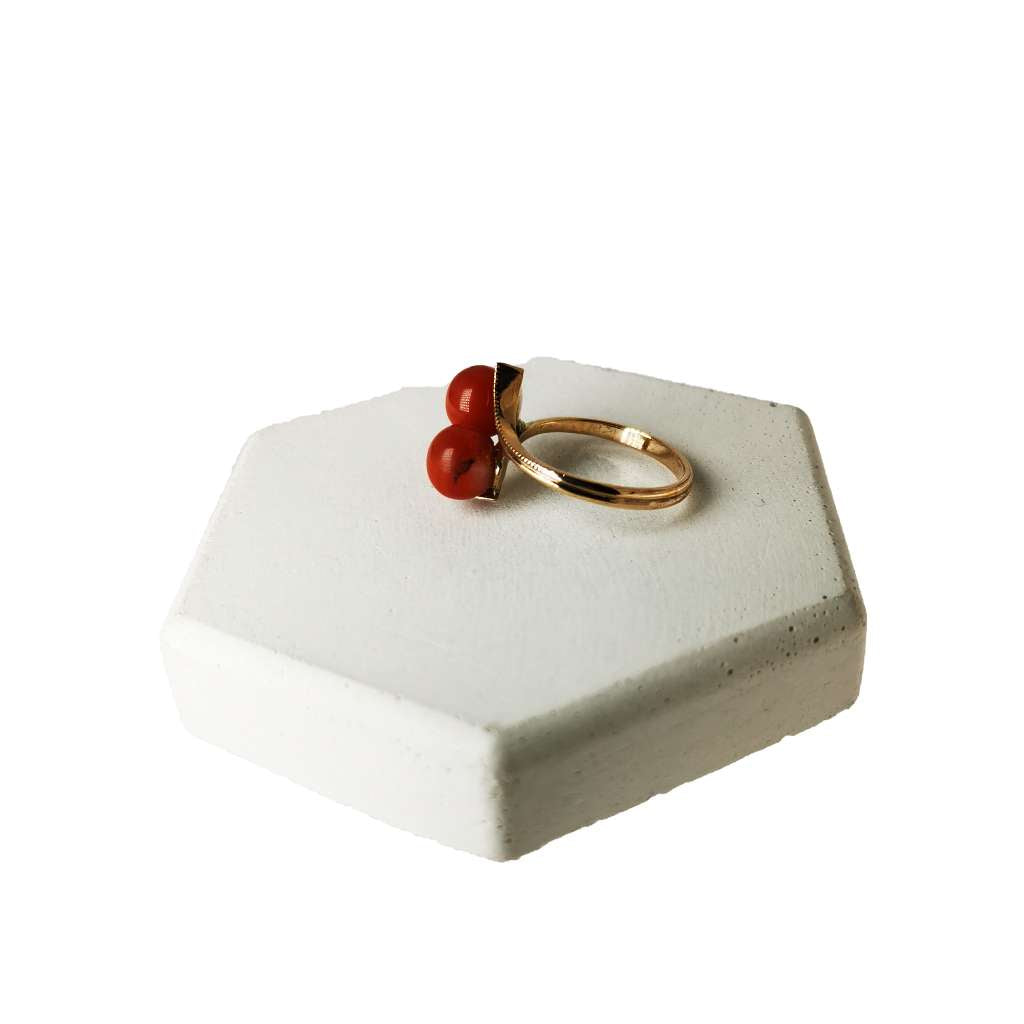 Top angle view of elegant 10kt rose gold ring showcasing two round red coral beads, size 6 ring