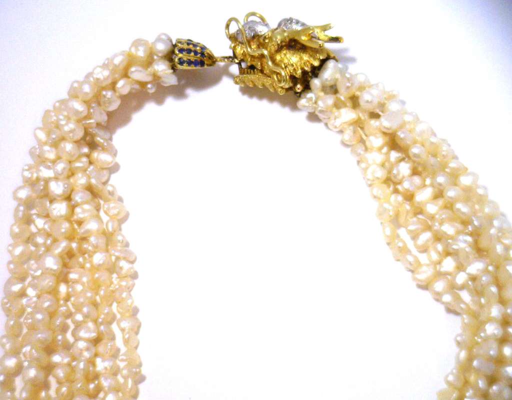 Elegant eight strand freshwater pearl necklace featuring 14kt yellow gold dragon style clasp with blue sapphires and diamonds, front view