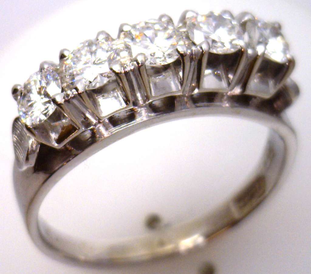 Detailed view of five round brilliant diamonds on white gold ring capturing brilliance and luster