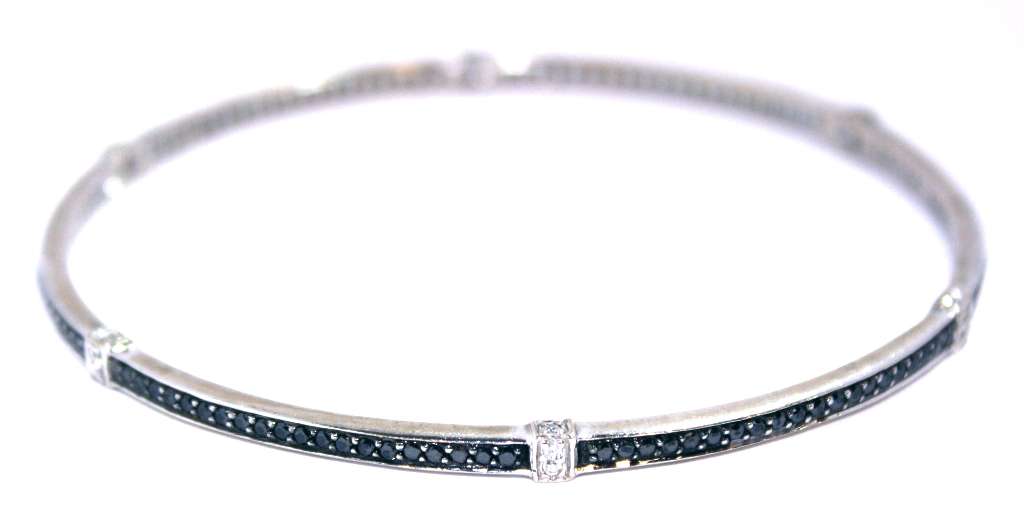 Side profile of elegant 18kt white gold bangle with contrasting white and black diamonds, weighing 14.35 grams