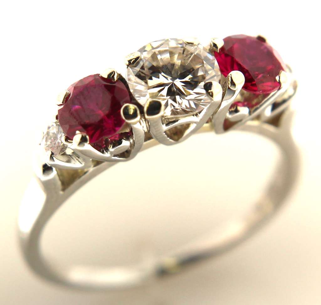 18kt white gold dinner ring front view showcasing center round brilliant diamond 0.62ct and two synthetic rubies