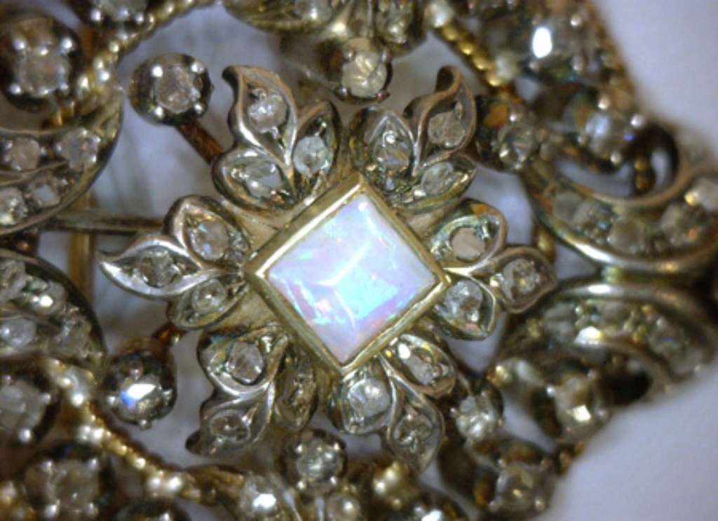 Side angle of Victorian brooch highlighting pear-shaped opal dangle in bezel setting with rose-cut diamonds