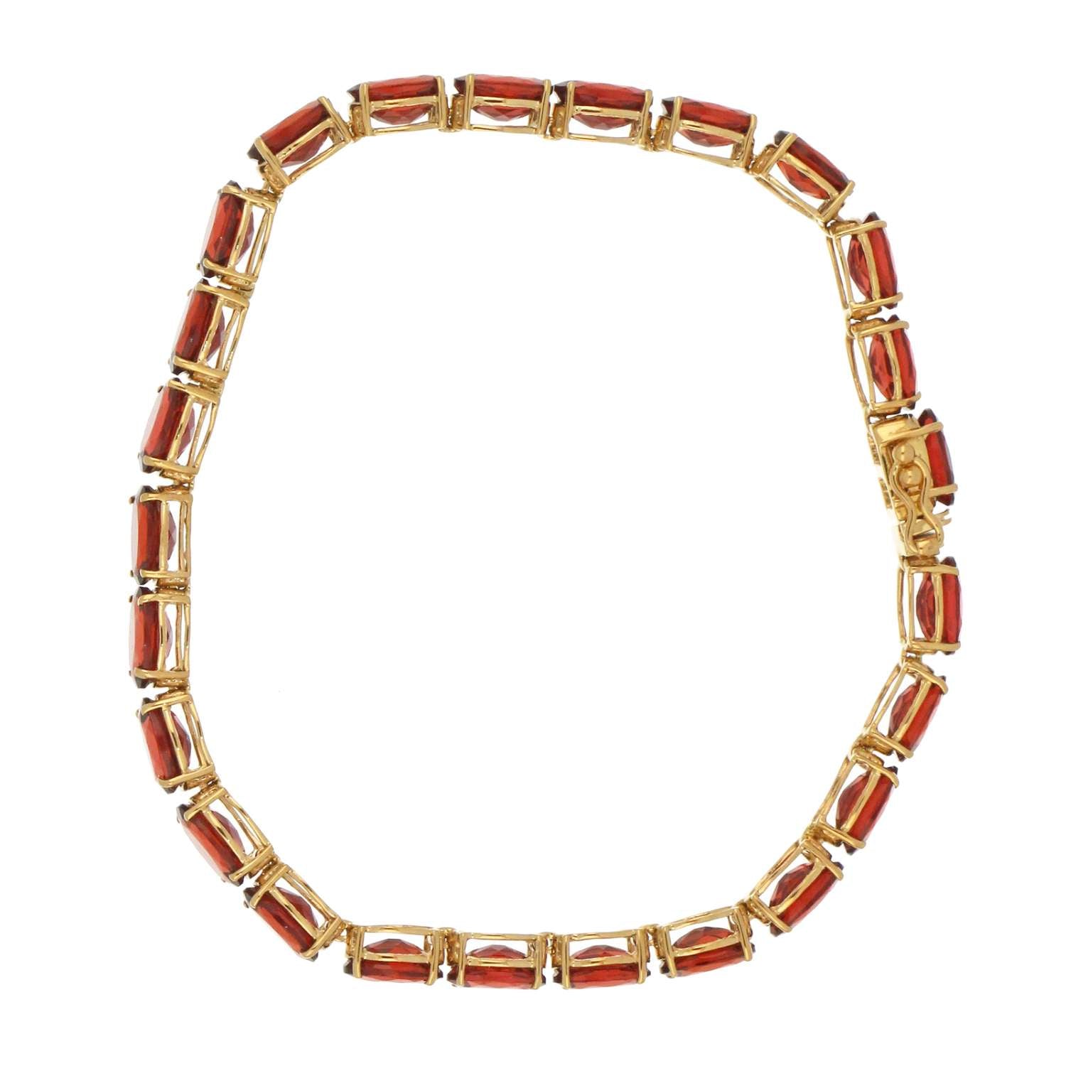 Full length view of yellow gold bracelet featuring 25 oval garnet gemstones