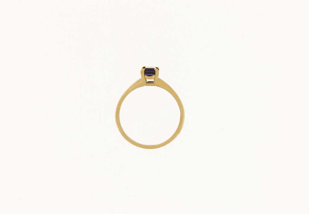 Detailed macro shot of authentic 18kt gold and rare emerald-cut Iolite gemstone ring