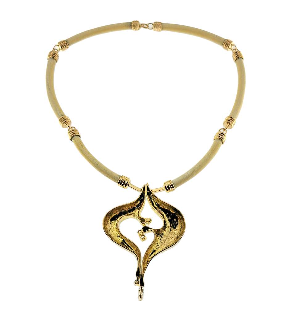 Detailed view of animal bone and diamond accents on a 14kt yellow gold necklace weighing 50.48 grams