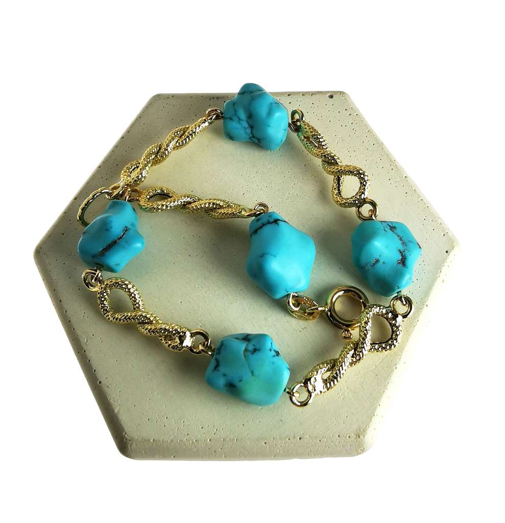 Close-up of 18kt yellow gold bracelet featuring five uniquely shaped green turquoise stones, showcasing bracelet length and craftsmanship