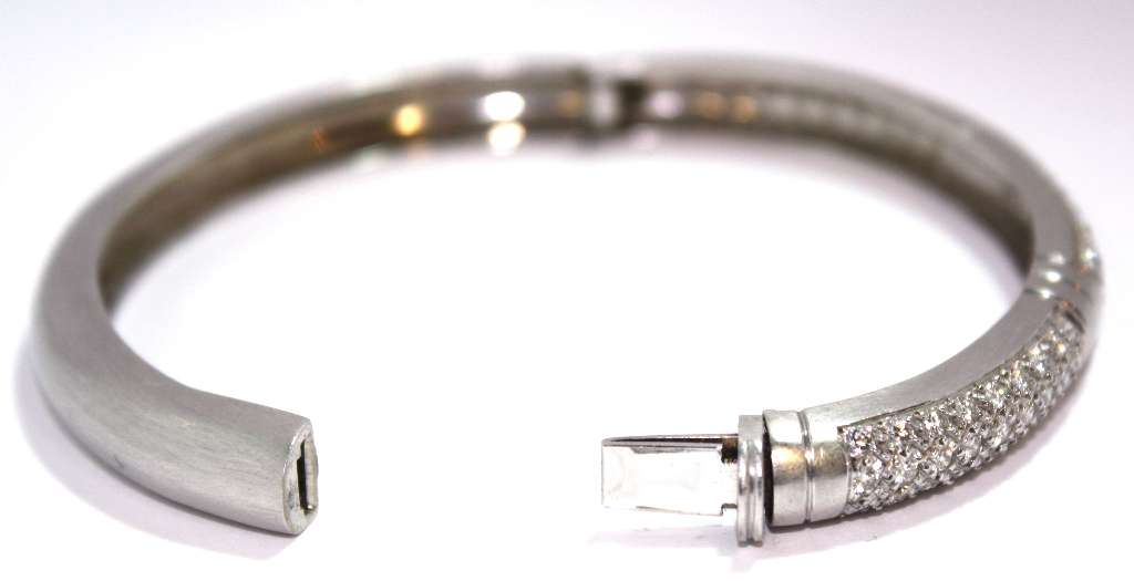 Luxury 18kt white gold bangle illuminated to reveal 81 VS clarity, G-H color diamonds with total weight 2.43cttw