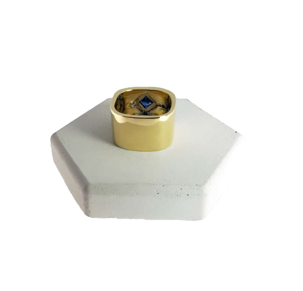 Top view of 18kt yellow gold band with square blue sapphire and surrounding full cut diamonds