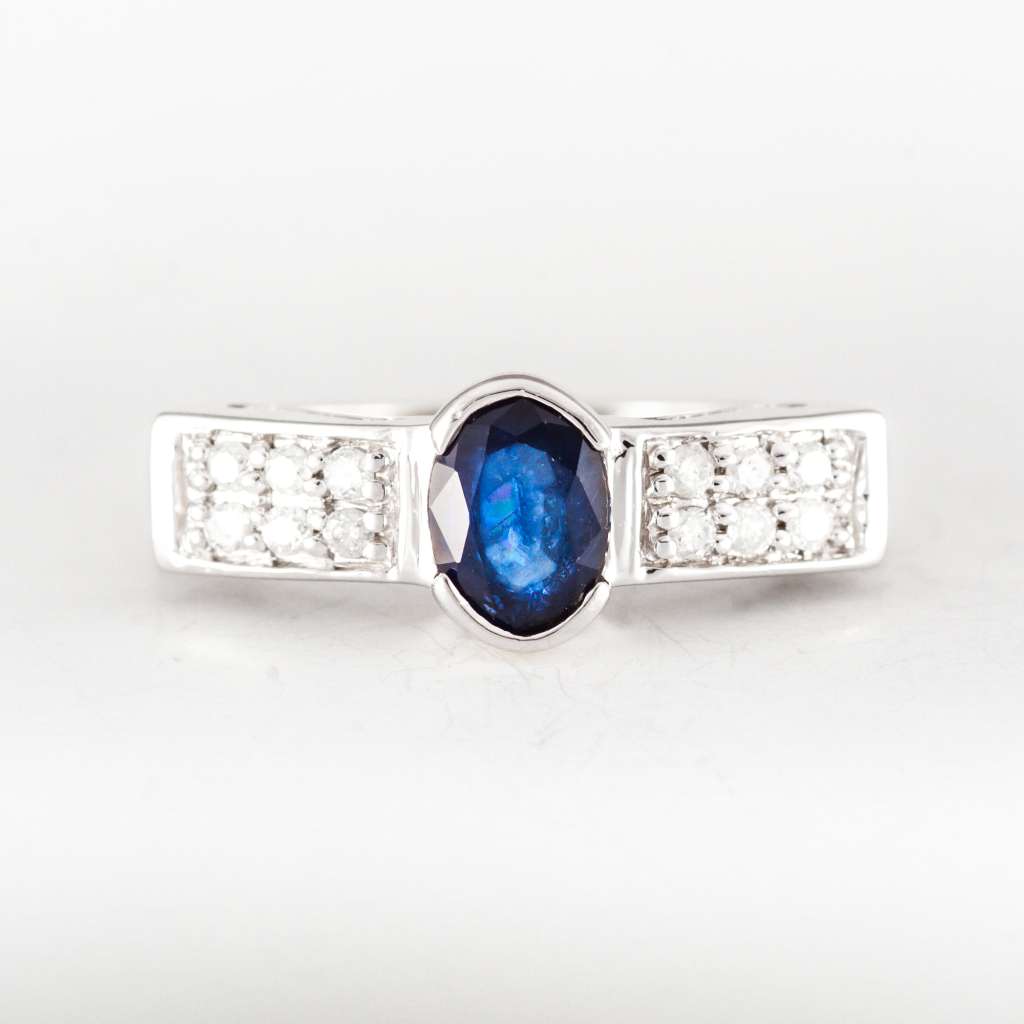 14kt white gold ring with oval blue sapphire center and round diamonds viewed from front angle